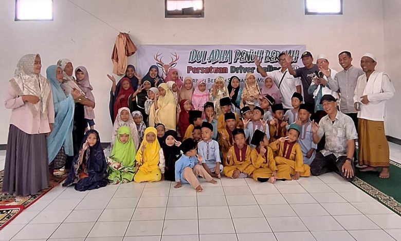 Sekelompok orang, termasuk anak-anak, berpose dalam ruangan dengan spanduk Idul Adha di belakang.